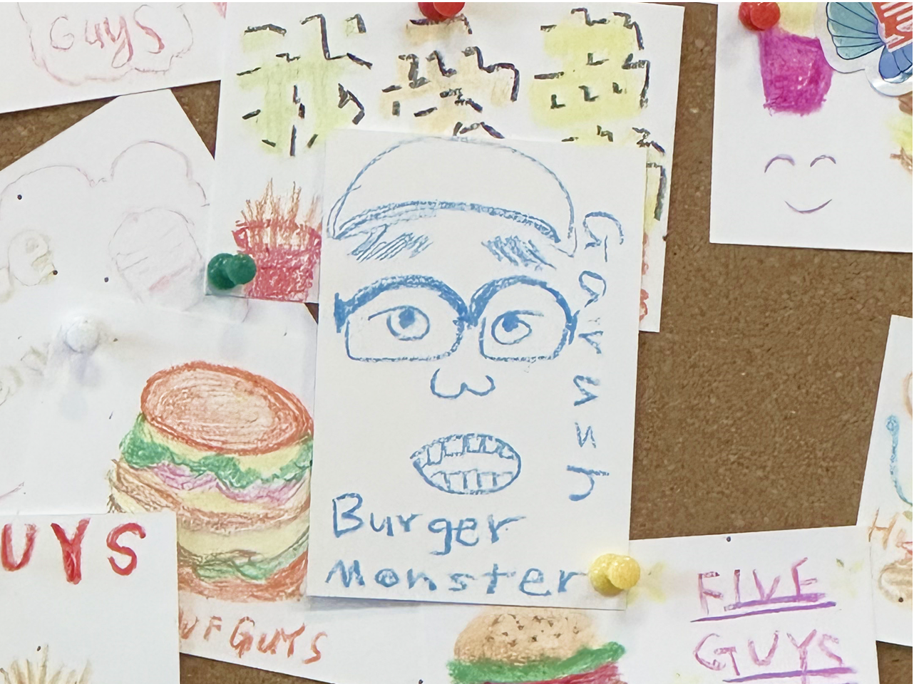 Children's drawings pinned to a board